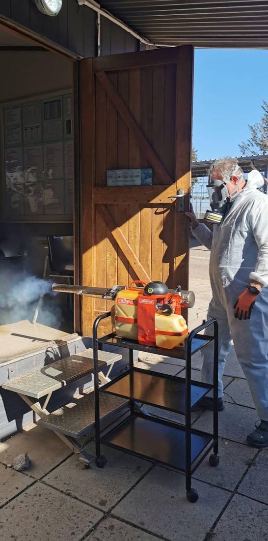Technician fogging a building through its open door